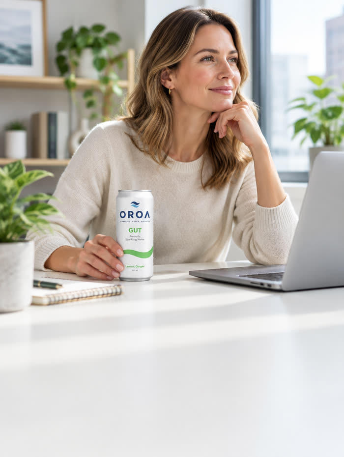 A woman working at a sunlit desk with an OROA GUT can beside her